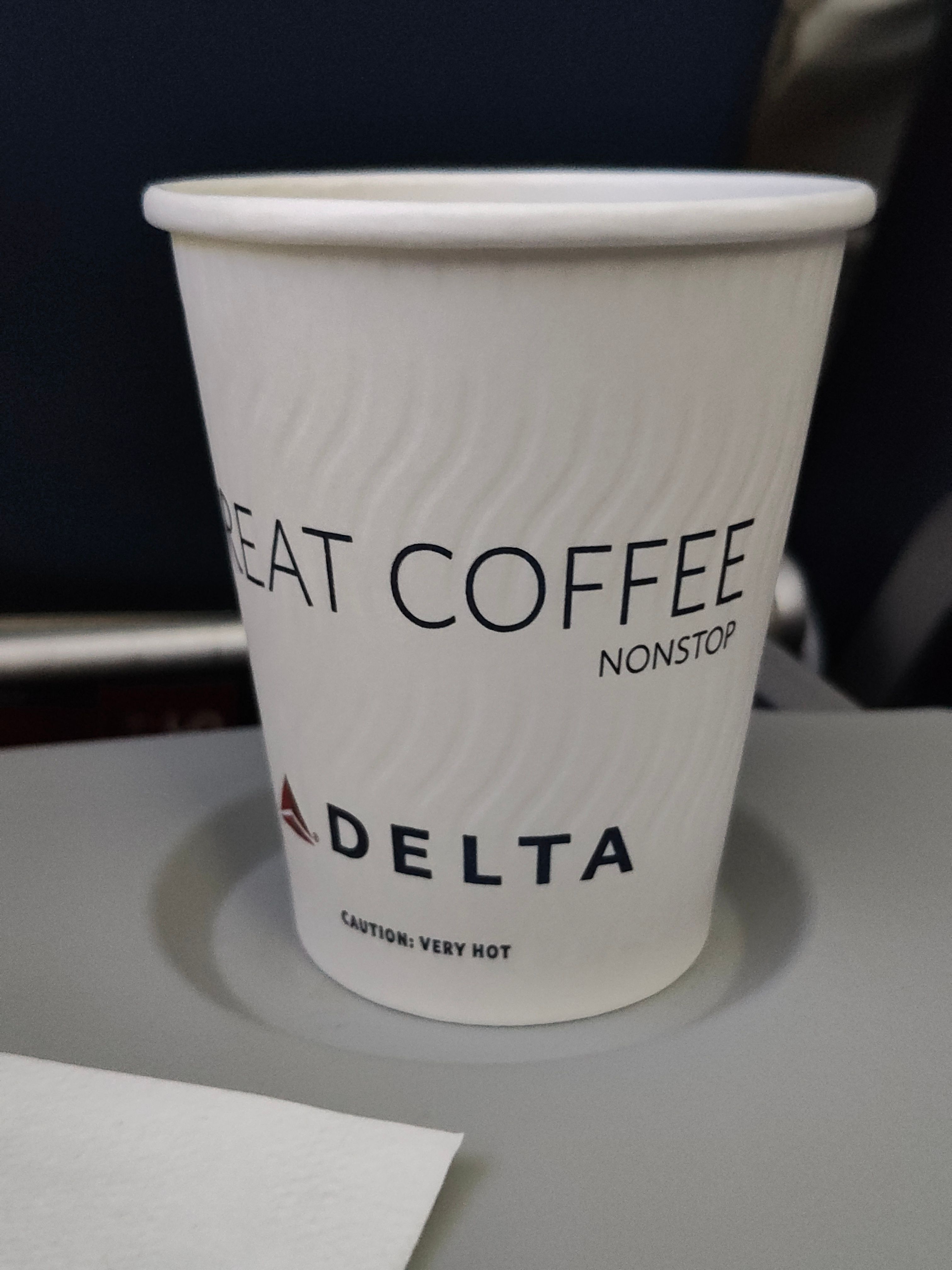 a paper cup that has been turned such that it shows the words EAT COFFEE NONSTOP