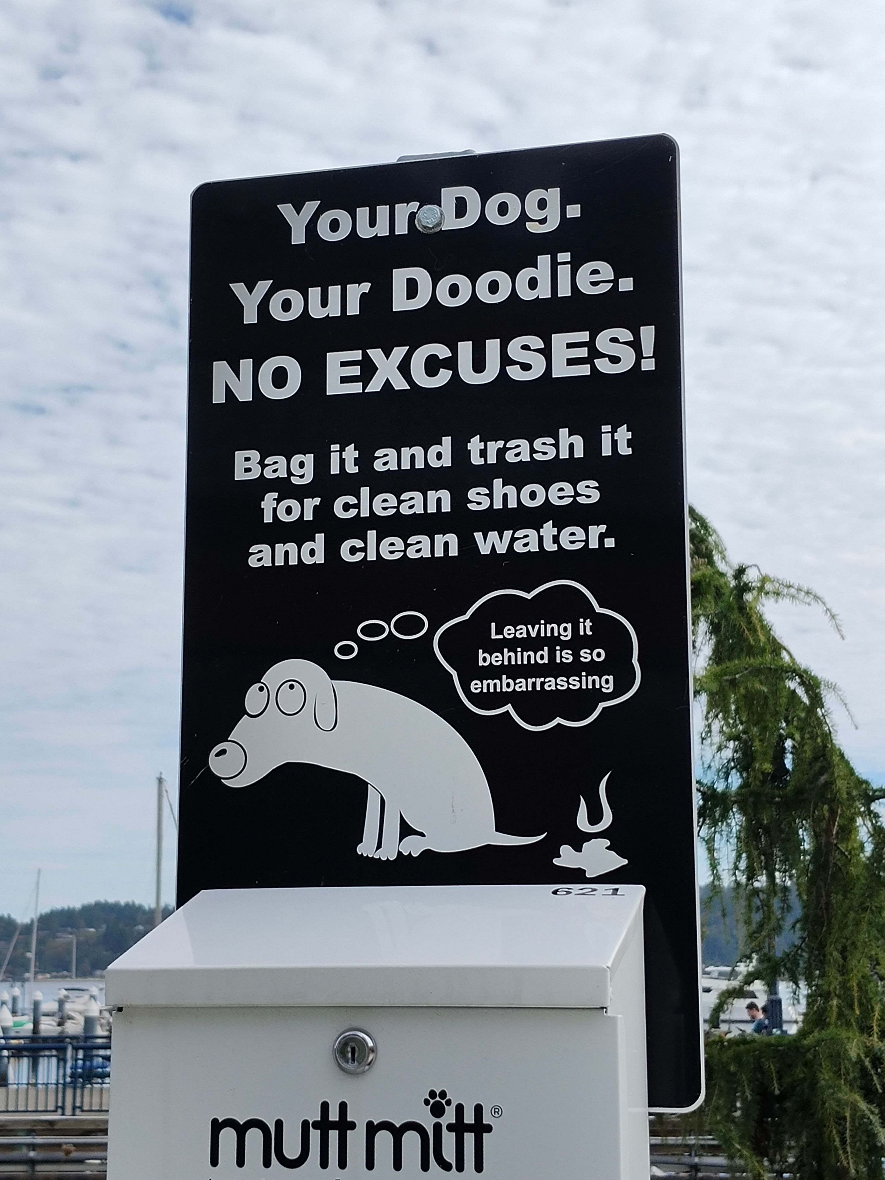 Sign that reads: Your Dog. Your Doodie. NO EXCUSES! Bag it and trash it for clean shoes and clean water. Below, a dog sitting next to a stinky poop with a thought bubble: Leaving it behind is so embarrassing